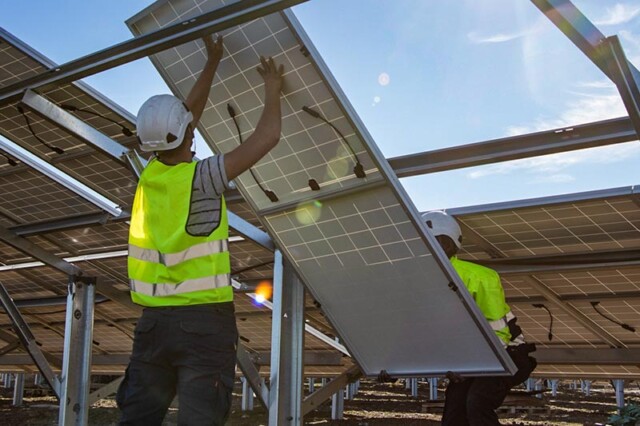 Due uomini che assemblano un impianto solare fotovoltaico